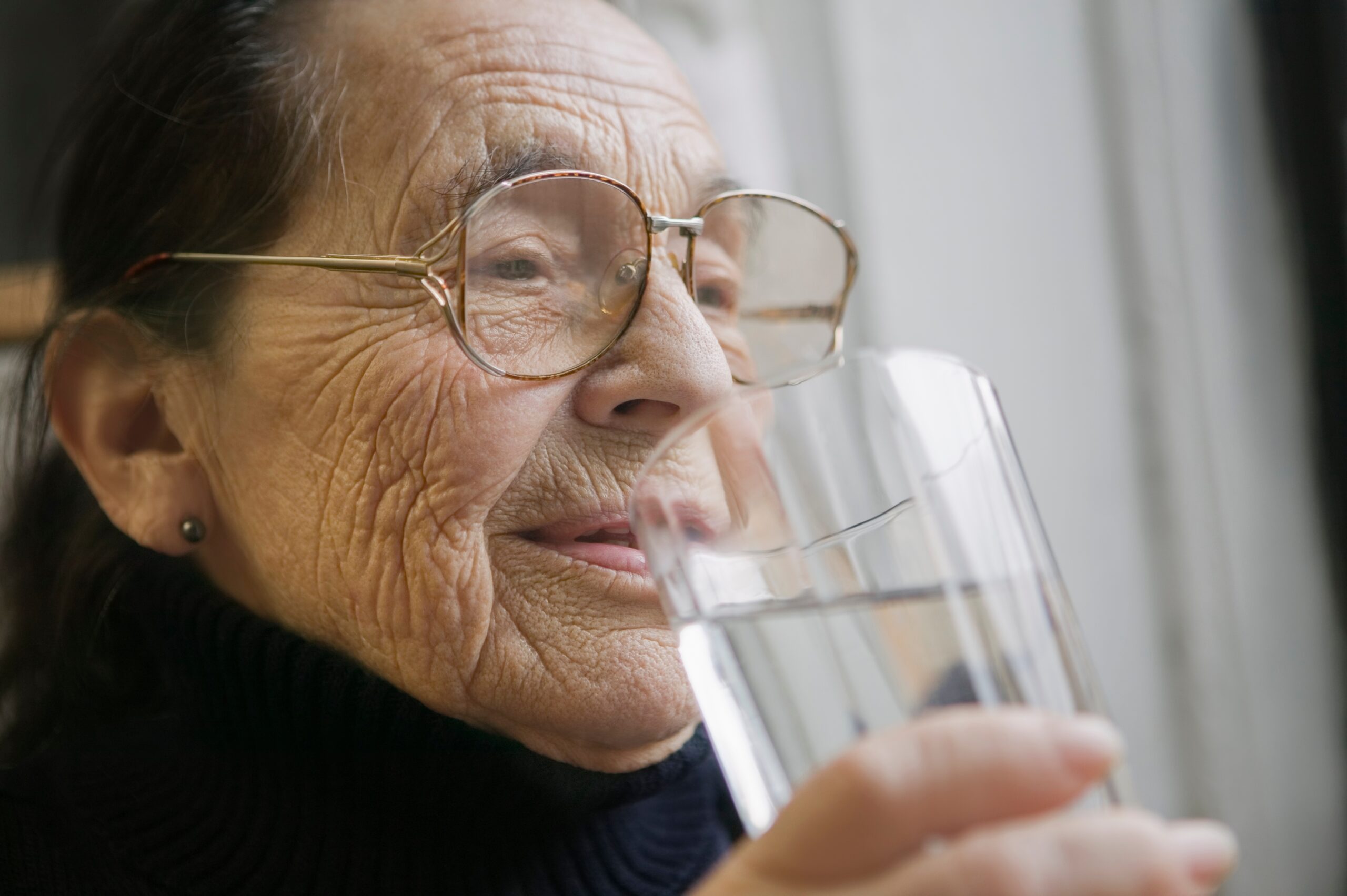 Adulto mayor con vaso de agua
